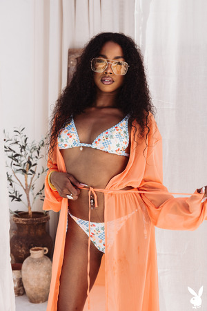 Mia Love Unties A Papaya Print Bikini Between Clay Jars - Photo 01